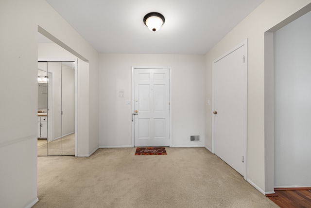 foyer entrance featuring carpet