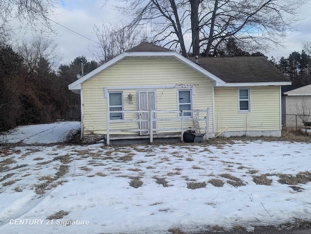 snow covered house with a shingled roof