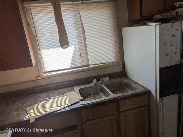 kitchen featuring a sink and dark countertops