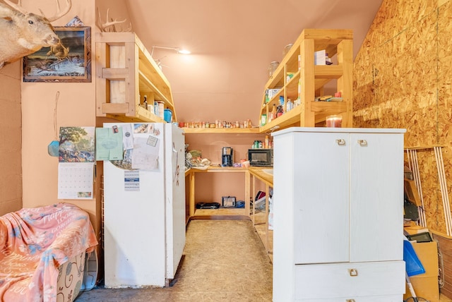 kitchen featuring white cabinets and white fridge