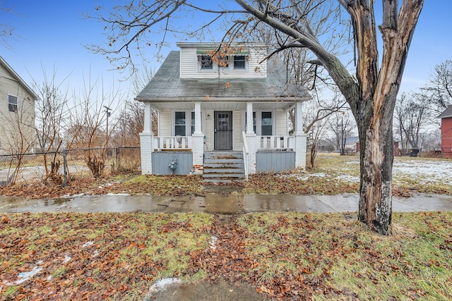 bungalow-style house with covered porch and fence