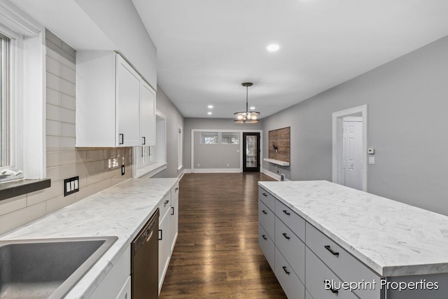 kitchen with decorative light fixtures, white cabinetry, dishwashing machine, backsplash, and a center island