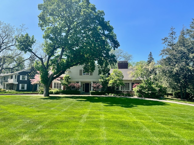 view of front of property featuring a front lawn and a chimney