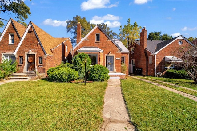 view of front facade with a front yard and brick siding