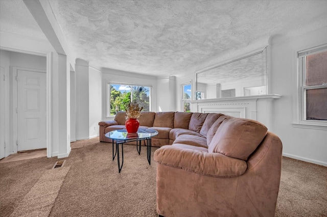 living area with visible vents, light carpet, a textured ceiling, and baseboards