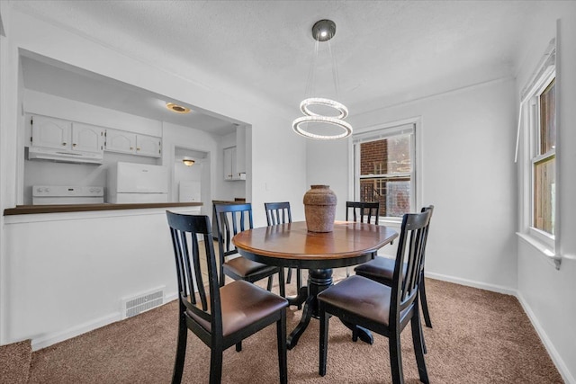 dining area featuring a notable chandelier, carpet, visible vents, and baseboards