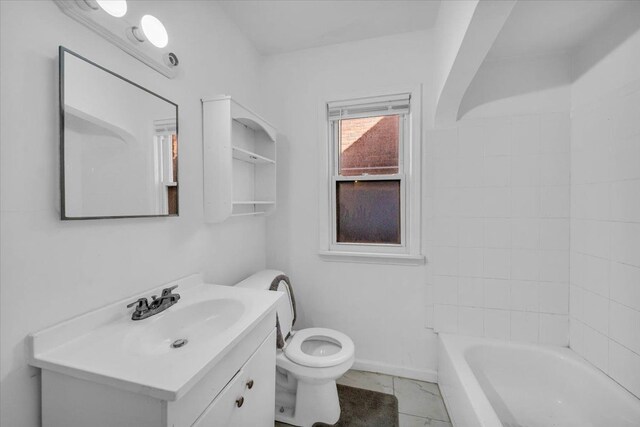 bathroom featuring toilet, vanity, and baseboards