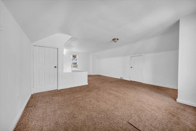 bonus room with carpet floors, baseboards, and lofted ceiling