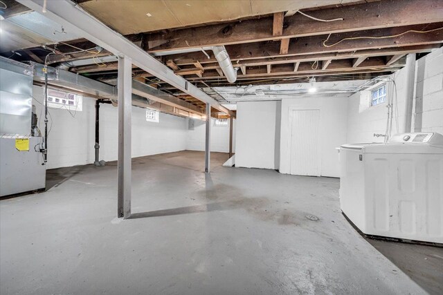 basement featuring heating unit and independent washer and dryer