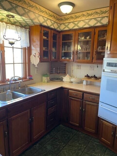 kitchen with tasteful backsplash, sink, and white oven