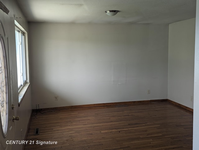 unfurnished room with dark wood-type flooring