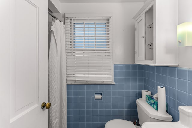 bathroom with toilet and tile walls