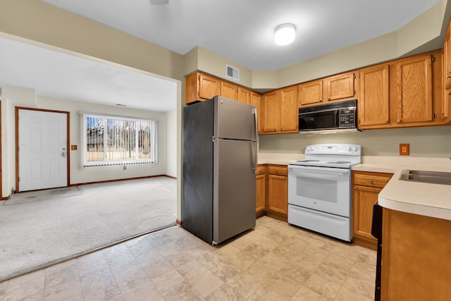 kitchen featuring electric stove, stainless steel fridge, sink, and light carpet