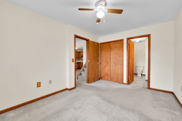 unfurnished bedroom with ceiling fan, light carpet, ensuite bath, and a closet