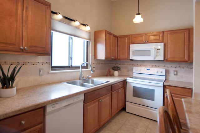 kitchen with sink, decorative light fixtures, light tile patterned floors, white appliances, and backsplash