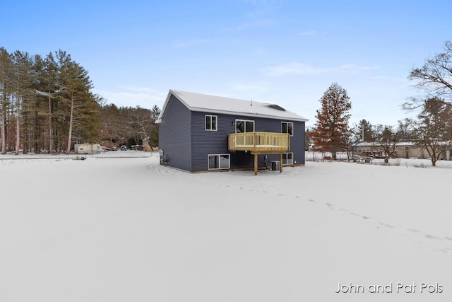 snow covered house with a wooden deck