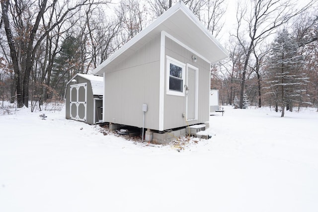 view of snowy exterior featuring a storage unit