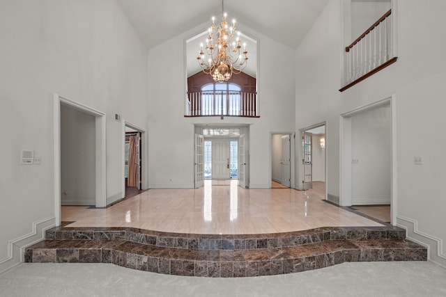 foyer with lofted ceiling, baseboards, and an inviting chandelier