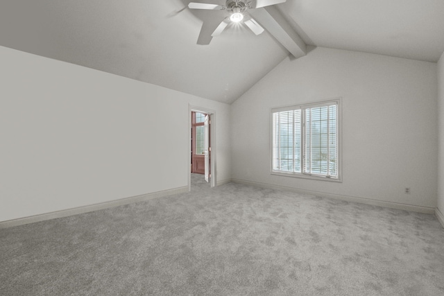 carpeted spare room with vaulted ceiling with beams, a ceiling fan, and baseboards