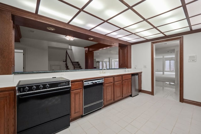 kitchen featuring black appliances, brown cabinetry, light countertops, and baseboards