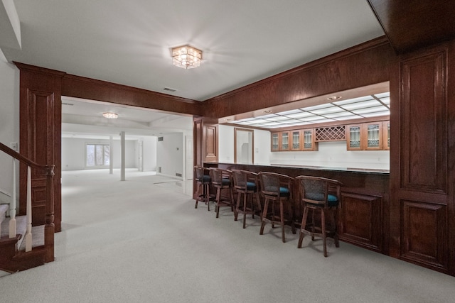 bar with visible vents, indoor wet bar, light carpet, and stairs