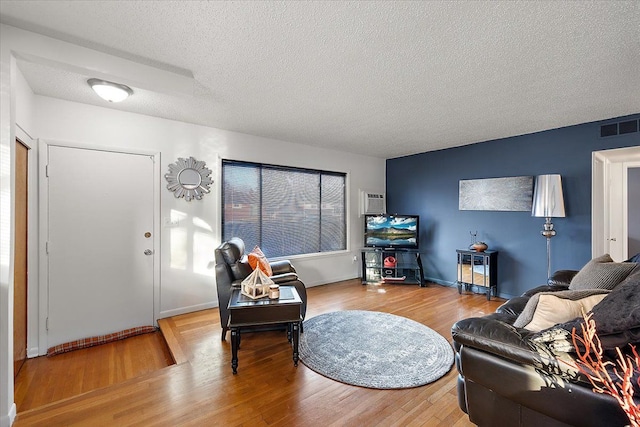 living room with hardwood / wood-style flooring and a textured ceiling