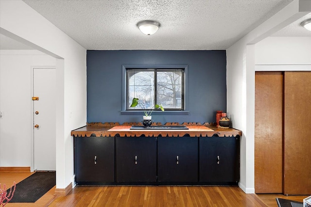 interior space with wood counters, light hardwood / wood-style floors, and a textured ceiling