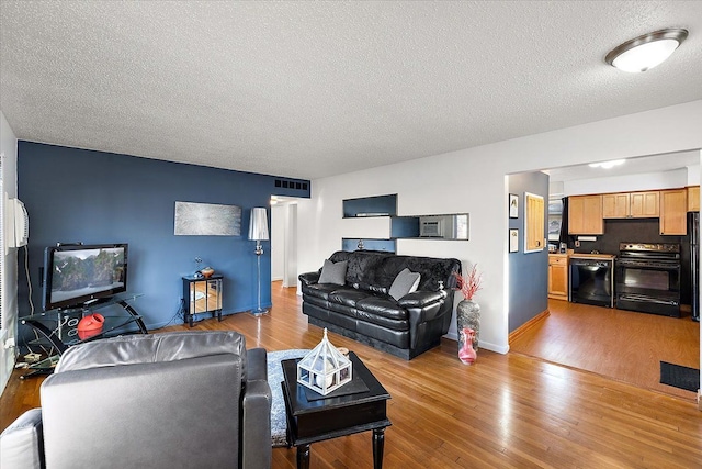 living room featuring a textured ceiling and light wood-type flooring