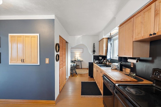 kitchen with light wood-type flooring, sink, light brown cabinets, and black appliances