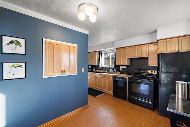 kitchen with a textured ceiling, light wood-type flooring, and black appliances