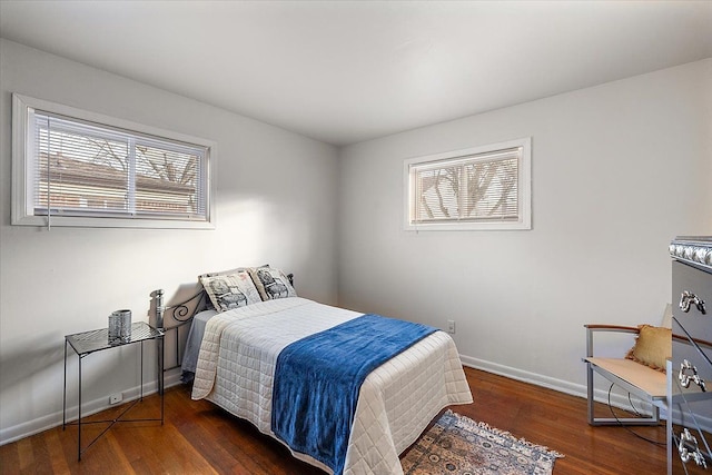 bedroom featuring multiple windows and dark hardwood / wood-style flooring