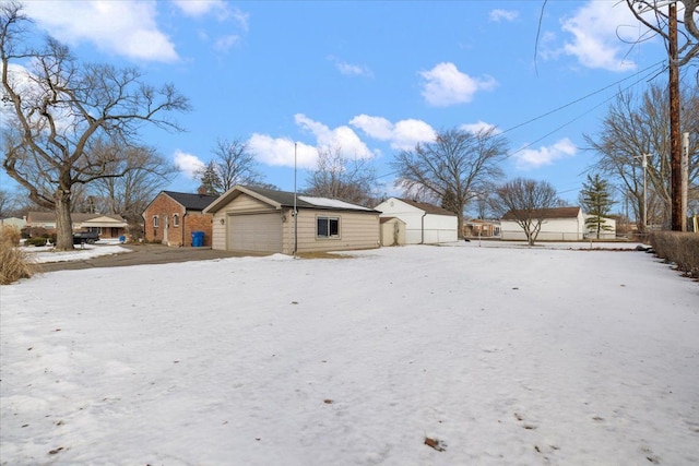 snowy yard featuring a garage