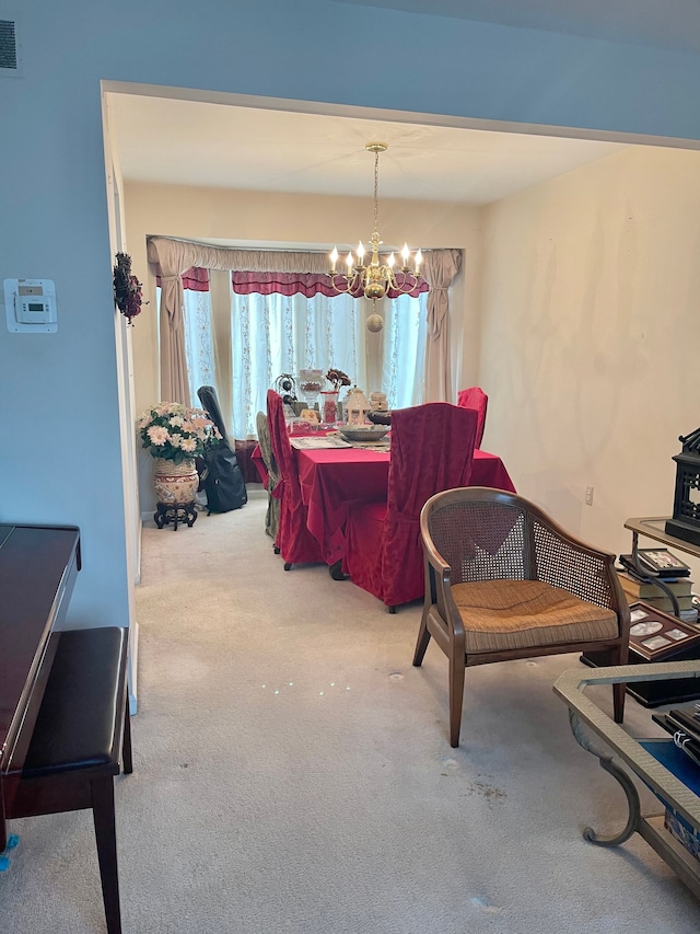 dining room featuring a notable chandelier, light carpet, and a wood stove