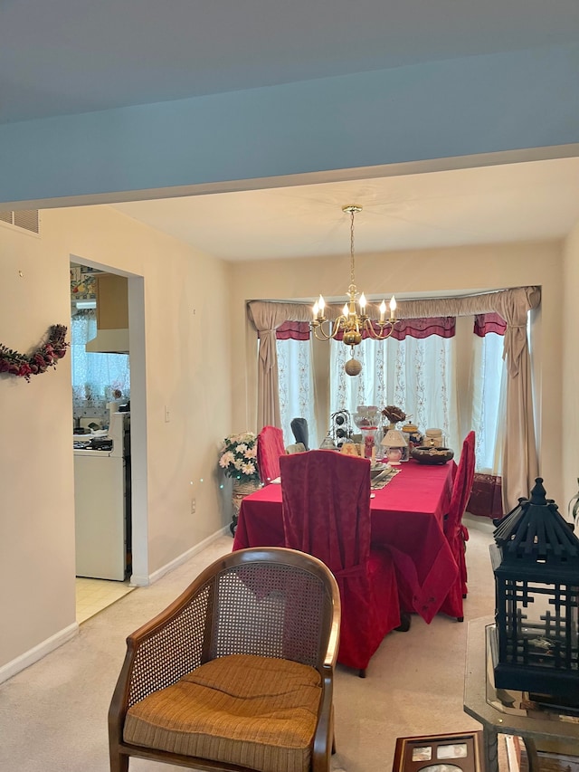 carpeted dining space with a chandelier