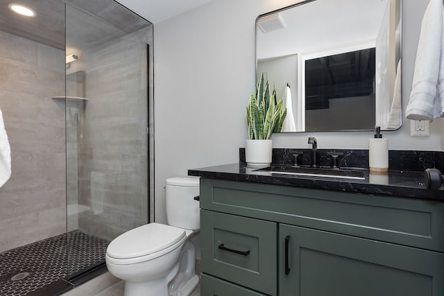 bathroom featuring an enclosed shower, vanity, and toilet