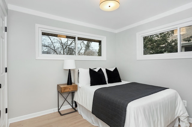 bedroom with ornamental molding and light hardwood / wood-style floors