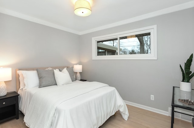 bedroom featuring crown molding and light hardwood / wood-style floors