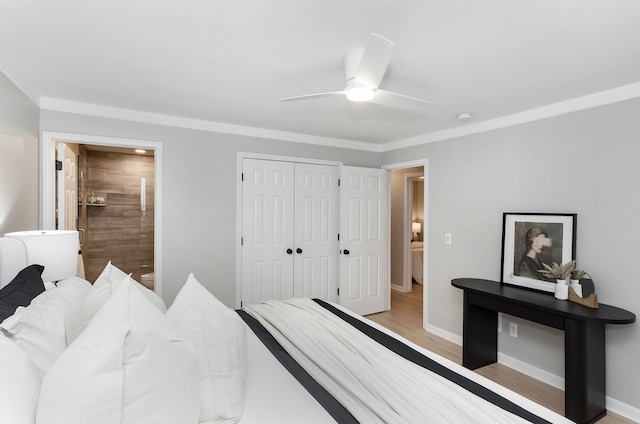 bedroom with ensuite bathroom, light hardwood / wood-style flooring, ceiling fan, crown molding, and a closet