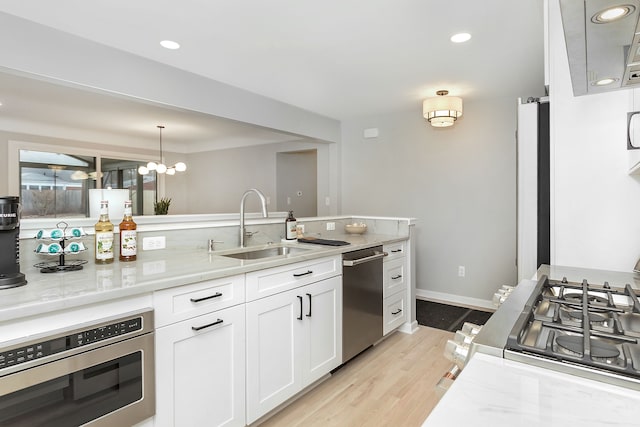 kitchen with light stone counters, white cabinetry, appliances with stainless steel finishes, and pendant lighting