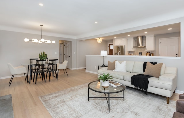 living room with an inviting chandelier and light hardwood / wood-style flooring