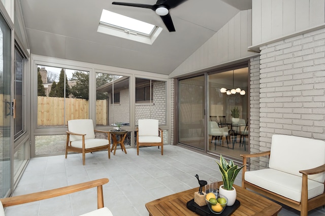 sunroom / solarium featuring lofted ceiling with skylight and ceiling fan