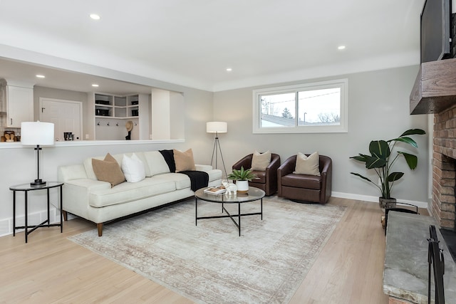 living room with a fireplace and light wood-type flooring