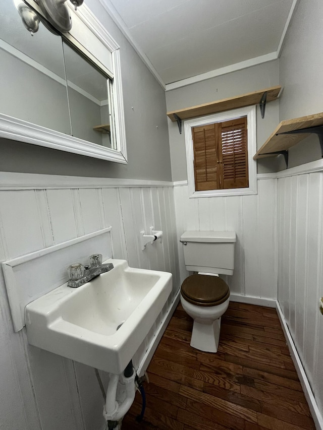 bathroom with hardwood / wood-style flooring, toilet, sink, and crown molding