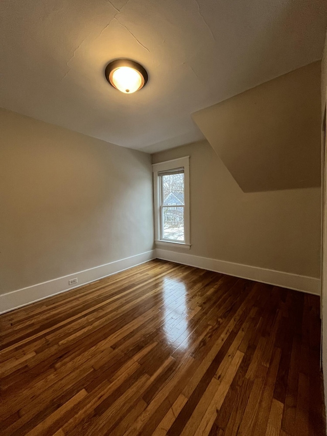 bonus room featuring dark wood-type flooring and vaulted ceiling