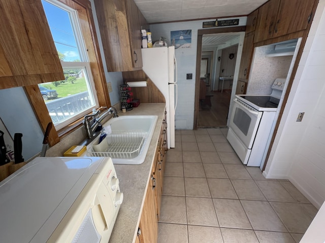 kitchen with sink, white appliances, and light tile patterned flooring