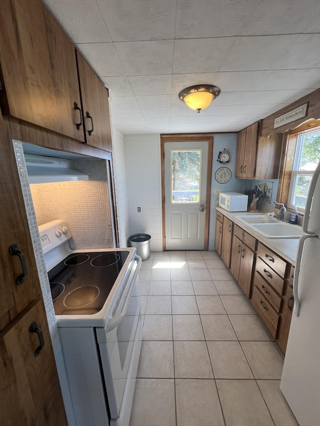 kitchen with sink, light tile patterned floors, and white appliances