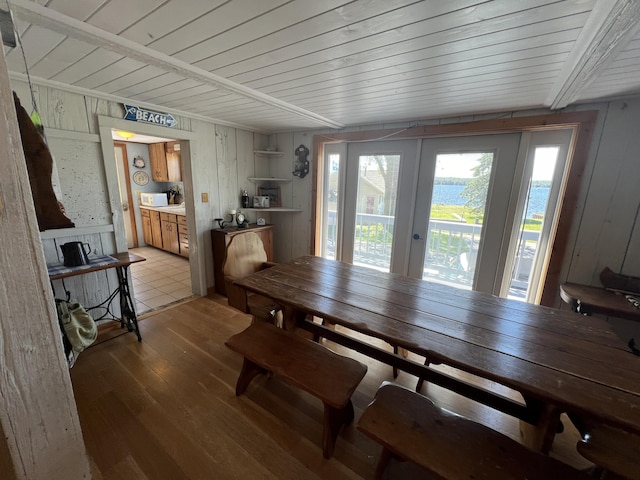 dining space with wood-type flooring, a wealth of natural light, wood ceiling, and french doors