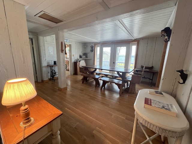 dining space featuring hardwood / wood-style flooring, wooden walls, wood ceiling, and french doors