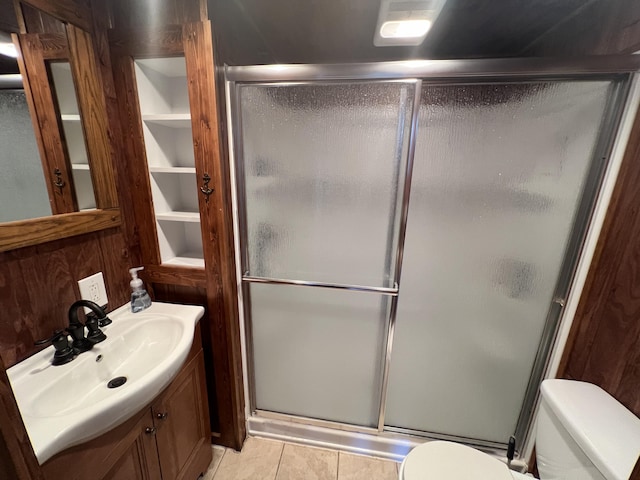 bathroom featuring tile patterned floors, vanity, toilet, and an enclosed shower