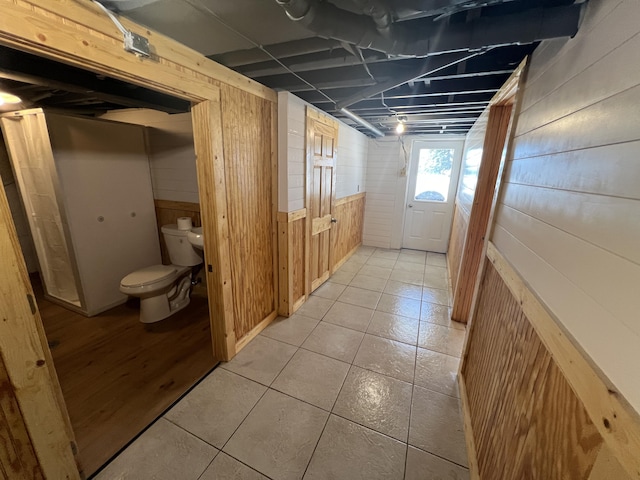 interior space featuring light tile patterned flooring and wood walls